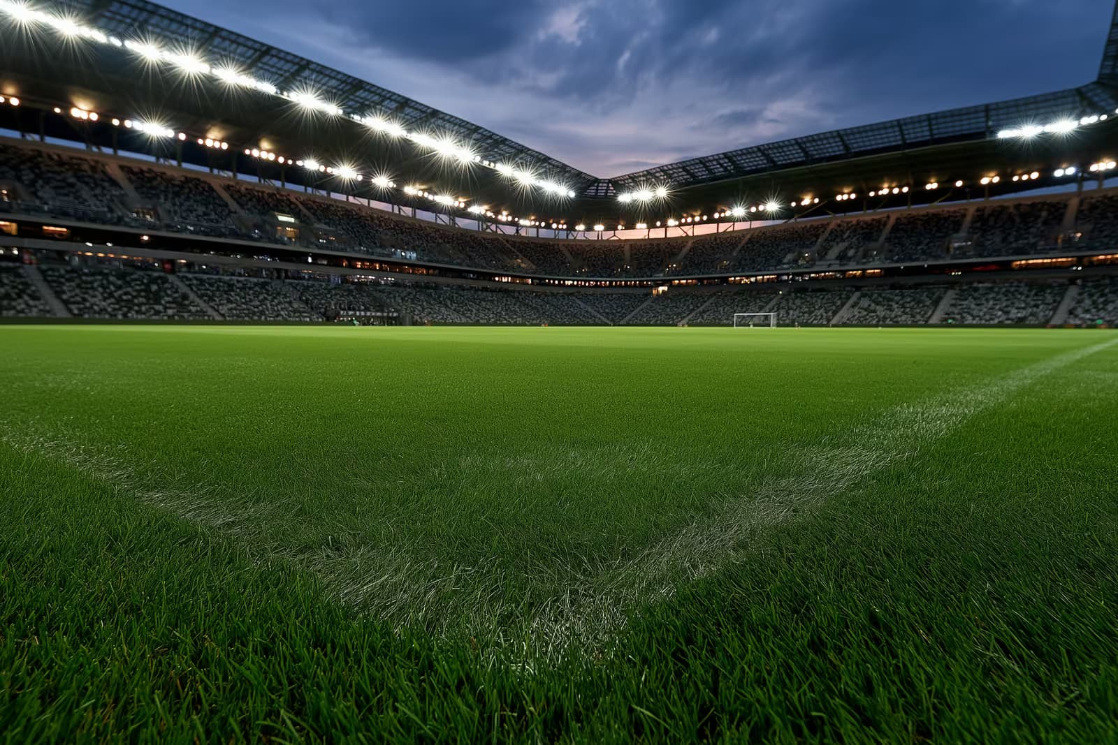 Akşam maçından önce, gün batımında ışıklandırılmış bir futbol stadyumu.